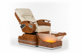 PRIVÉ Lounge flagship pedicure chair fully reclined in ivory and burlwood colorway with AURORA bowl glowing amber and chrome accents visible