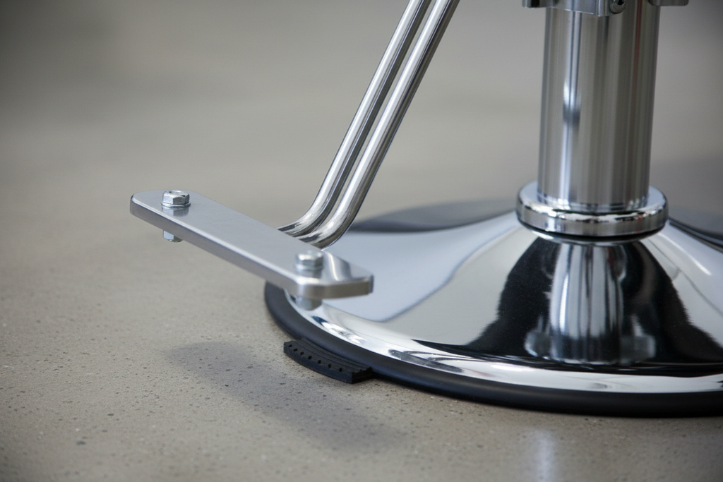Close-up of PRIVÉ Stationary Chair weighted chrome pedestal base showing non-scratch foot pad, base casting finish, and stem-to-seat connection plate